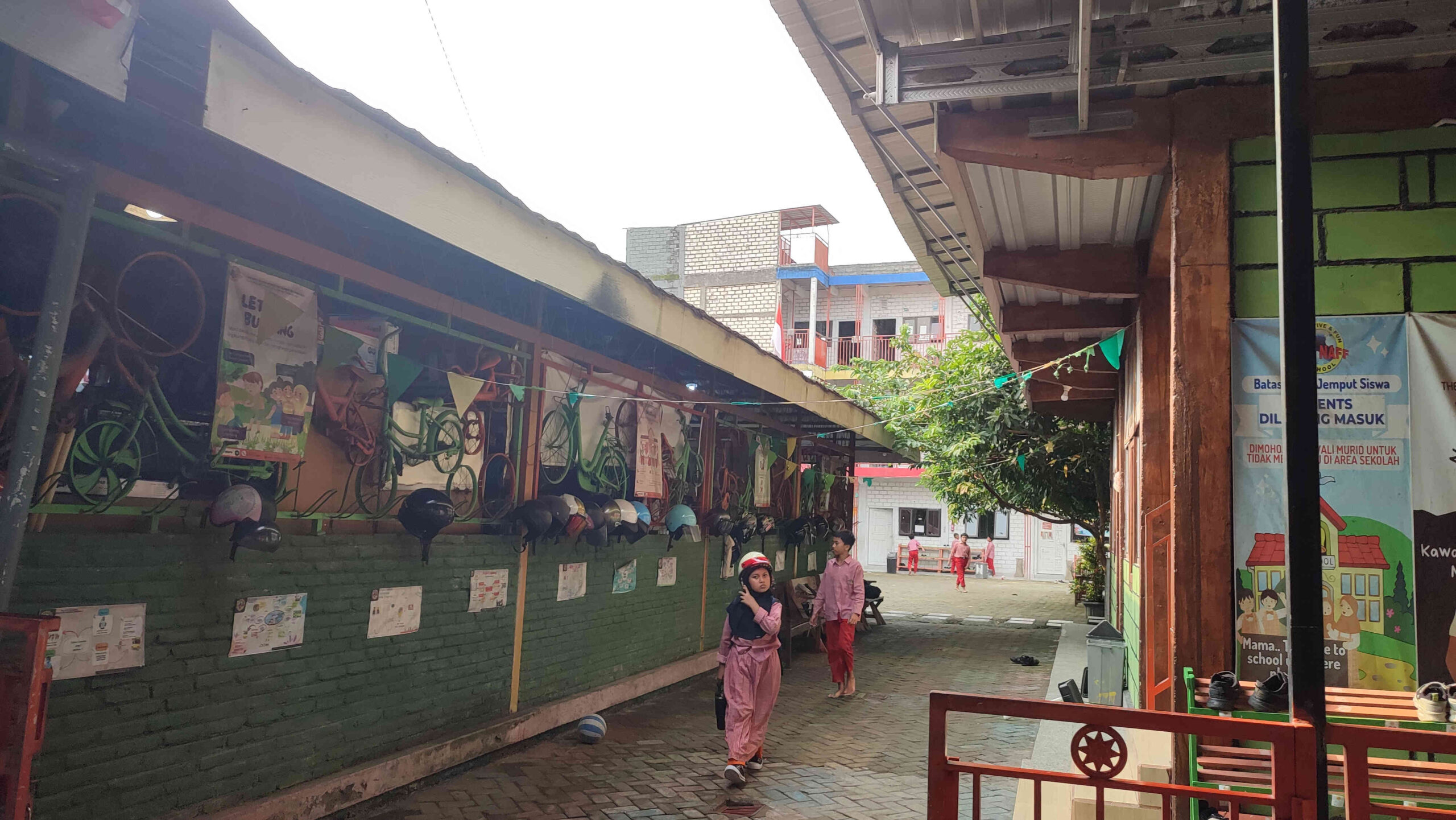 Siswa berjalan di lingkungan Gedung The Naff Elementary School Kediri yang disorot terkait izin PBG dan keamanan bangunan.