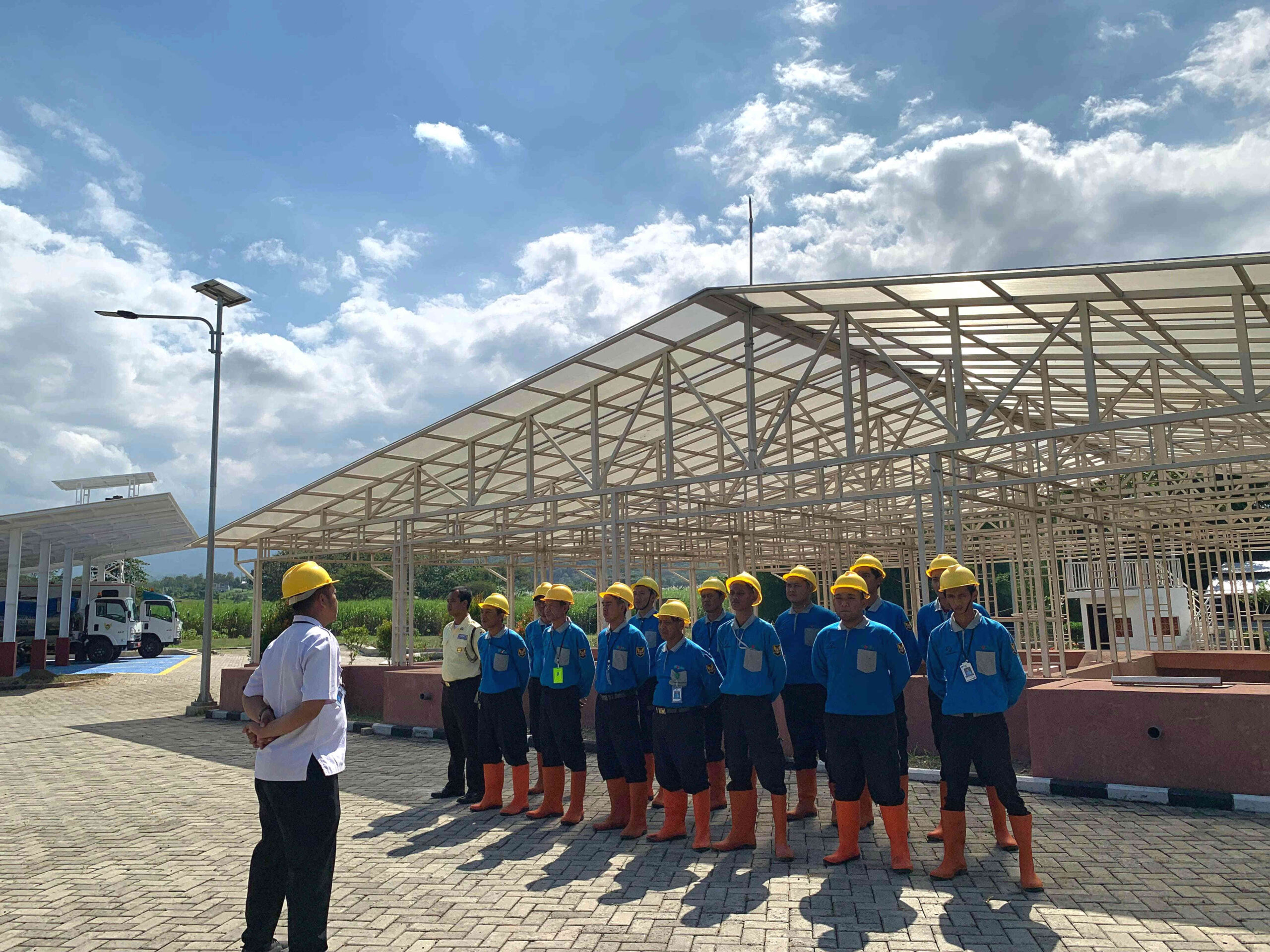 Petugas IPLT Kota Kediri mengikuti briefing di area Instalasi Pengolahan Lumpur Tinja (IPLT) Campurejo sebelum operasional layanan sanitasi domestik.