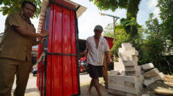 Mbah Mari bersama petugas Dinas Kopusmik Kabupaten Kediri memindahkan rombong kontainer merah bantuan dari Bupati Hanindhito Himawan Pramana (Mas Dhito) di Desa Manggis, Kecamatan Puncu.
