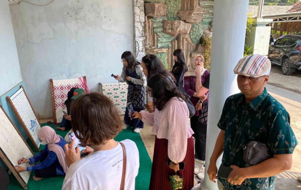 Delegasi internasional, akademisi Universitas Ciputra Surabaya, pemerintah Kota Kediri, dan pelaku Tenun Ikat Bandar Kidul berfoto bersama saat kunjungan ke sentra tenun dalam rangka pengembangan sekolah tenun di Kota Kediri.