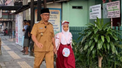 Wakil Wali Kota Kediri KH Qowimmudin Thoha (Gus Qowim) mengenakan seragam dinas ASN saat berjalan kaki mengantar putrinya ke sekolah SD Islam Bandarkidul pada hari pertama tahun ajaran baru.