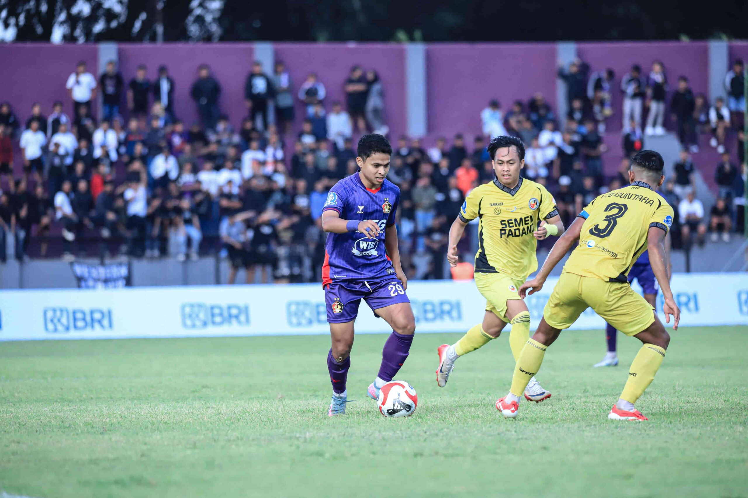Pemain sayap Persik Kediri Irkham Mila menggiring bola saat menghadapi dua pemain Semen Padang dalam pertandingan Super League 2025/2026.