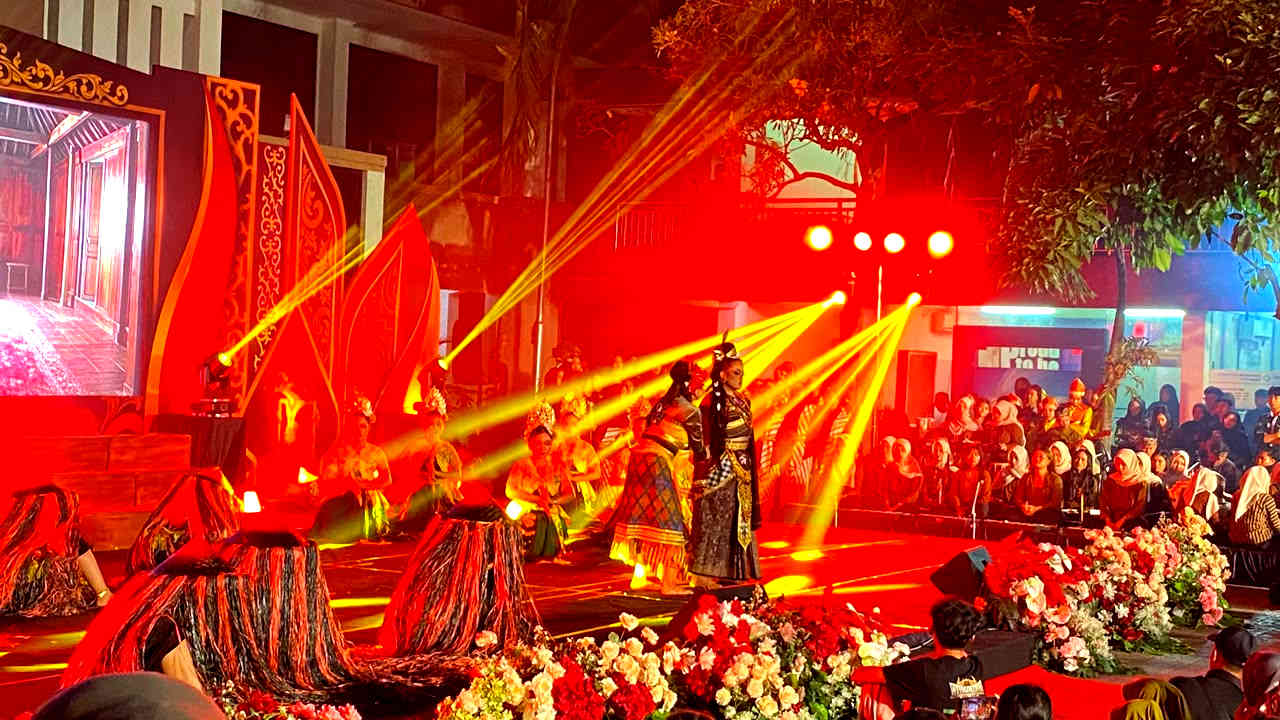 Ratusan penari mahasiswa PGSD UNP Kediri mementaskan drama tari kolosal Calon Arang di panggung terbuka Festival Kali Brantas V, menampilkan sosok Calon Arang di bawah cahaya lampu kuning yang megah, disaksikan ribuan penonton.