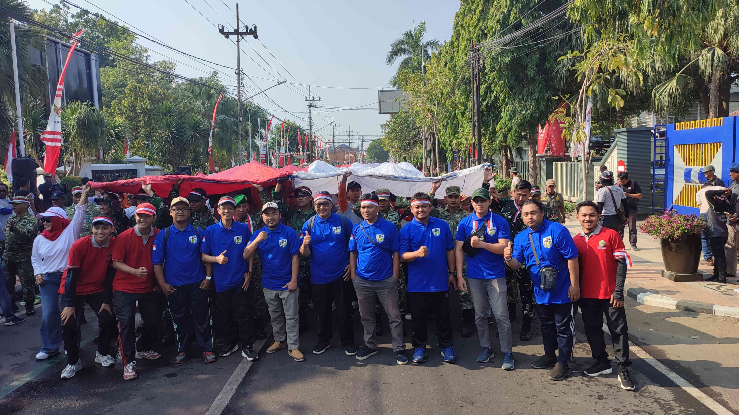 Jajaran pengurus DPD KNPI Kota Kediri membentangkan bendera Merah Putih raksasa dalam kegiatan kirab peringatan HUT ke-81 RI.