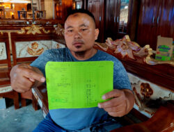 Pedagang menunjukkan kartu pencatatan pembayaran retribusi Pasar Pahing Kota Kediri.