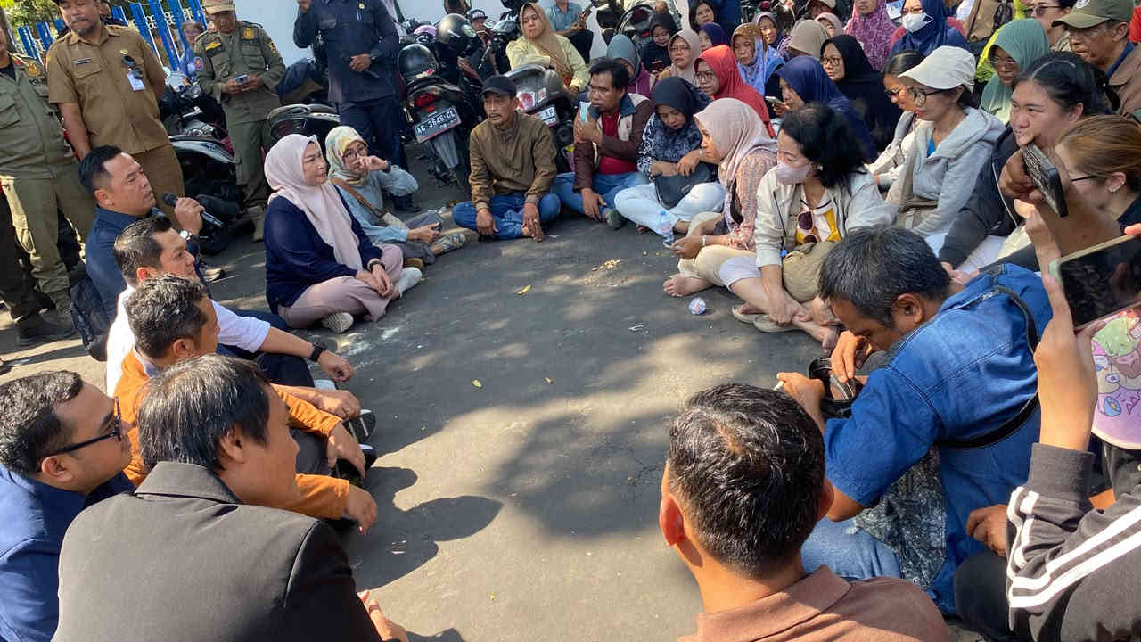 Ratusan pedagang Pasar Bandar dan Pasar Pahing duduk melingkar saat menggelar aksi demo menolak portal berbayar di DPRD Kota Kediri.