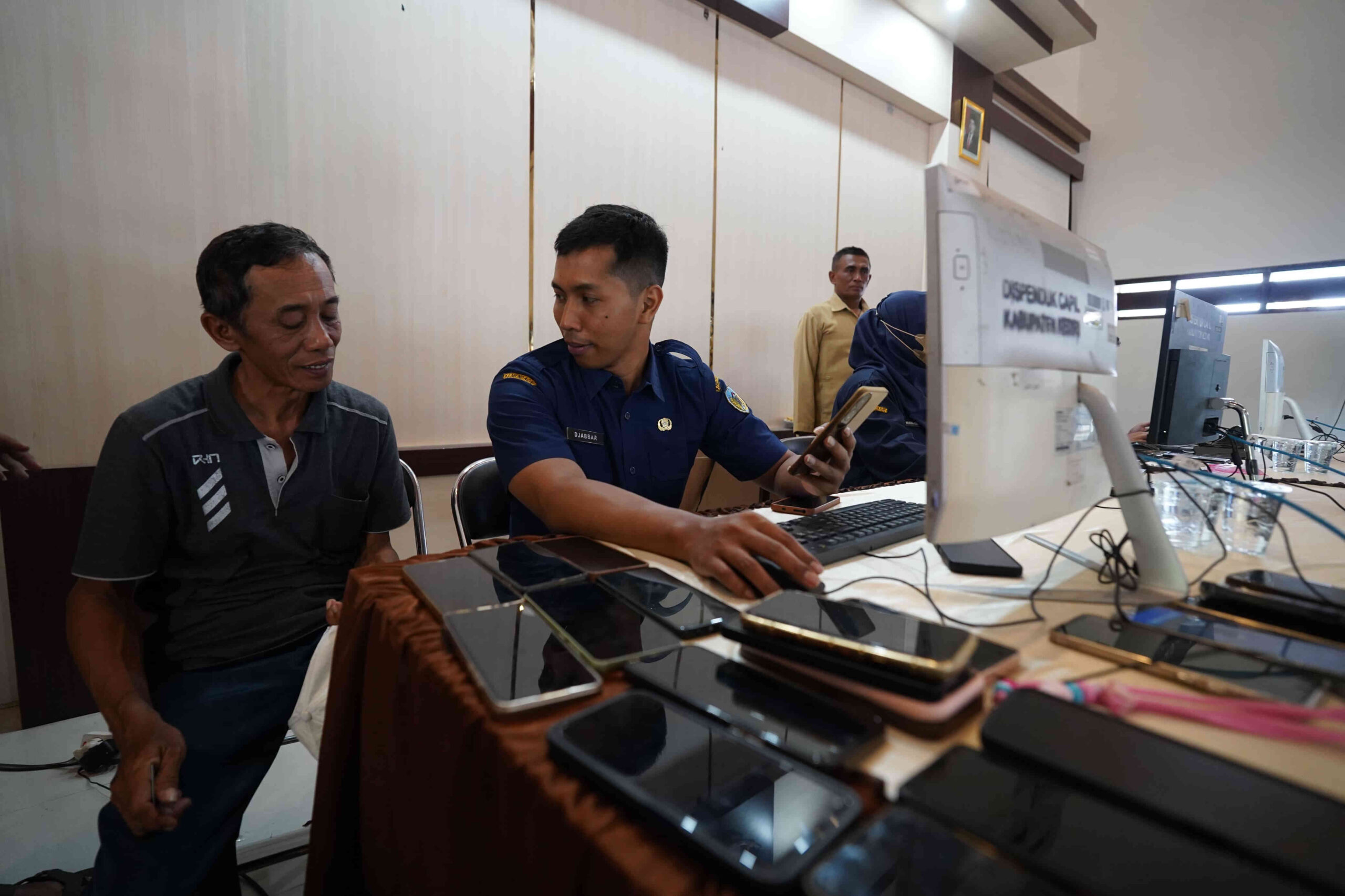 Petugas Dispendukcapil Kabupaten Kediri membantu warga melakukan aktivasi Identitas Kependudukan Digital (IKD) untuk pembenahan data pemenuhan bansos.