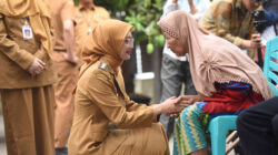 Vinanda Prameswati, Wali Kota Kediri, menggenggam tangan warga lansia penderita stroke saat kunjungan ke rumah warga.